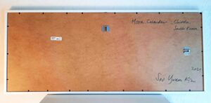 Backside of the framed moon calendar with handwritten title and signature